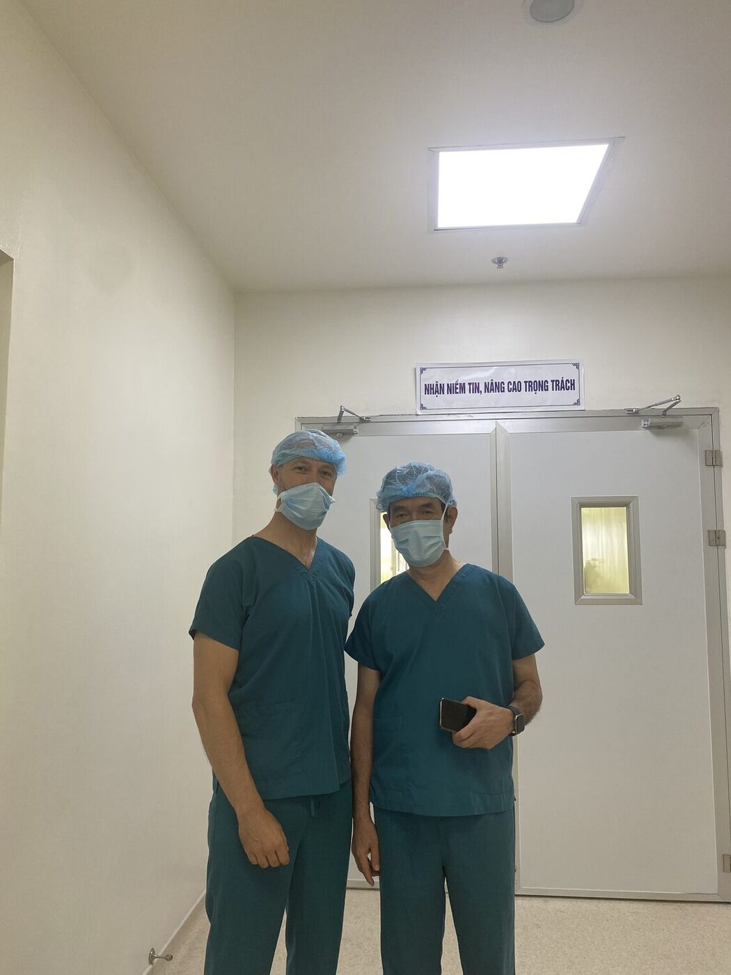 Our founder with a partner surgeon at the operating theatre doors in Vietnam