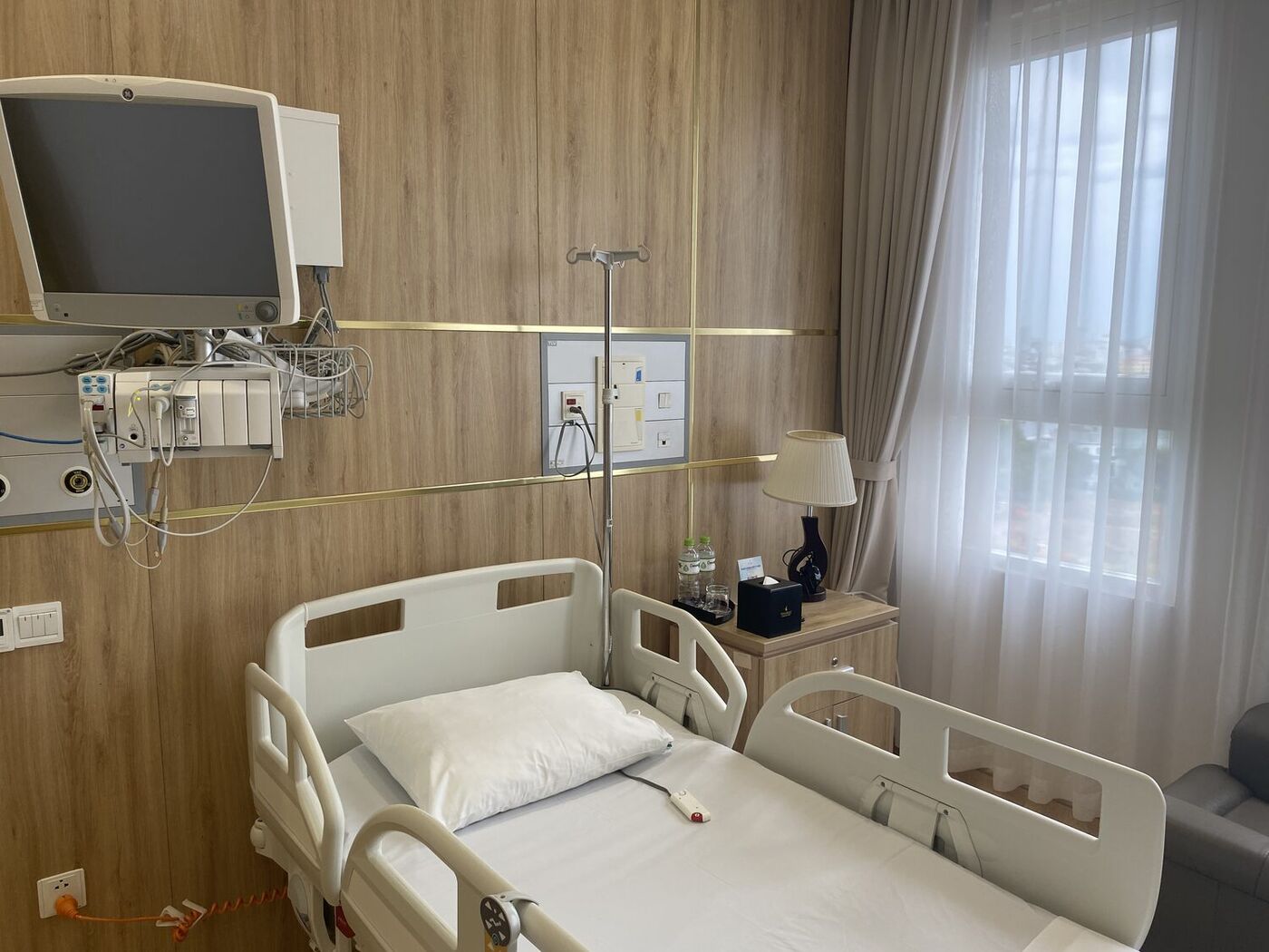 A private patient room with a recliner and city view in Vietnam